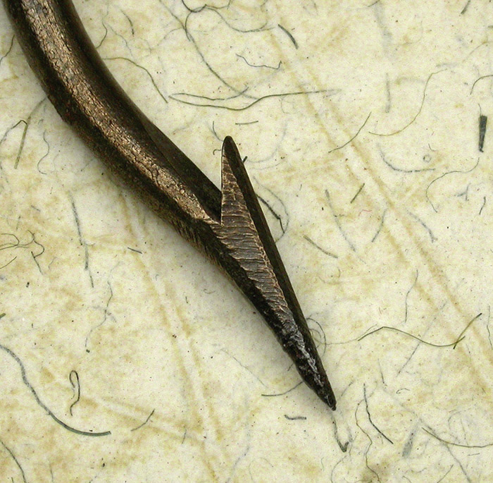 32c Washburn, sample hook, 13/0, hand formed tapered, welded ring eye, bronzed, ca 1904. The eye on this hook is very big, you could put a ¼” rope through it. The hand filing is great. You can imagine the hook maker filing the wire to a very fine taper and then bending it, what looks to me to be freehand. I have three of these hooks that are all slightly different. The original tag reads, Washburn, Sample, April 1904, a triangle-S &, to trade, C or G ss and the cents symbol. Were these prototype hooks? I don’t recognize the name. There’s a story there that we are unlikely to know. 1900’s collection.
