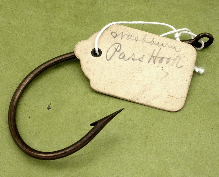 34. The third Washburn, sample hook, 13/0, hand formed tapered, welded ring eye, bronzed, ca 1904. The eye on this hook is also big but smaller than the other two. Once again, the hand filing is great. The original tag reads, Washburn, Pass Hook. The same as the other two except this one is reversed (bent the opposite of kirbed). 1900’s collection.
